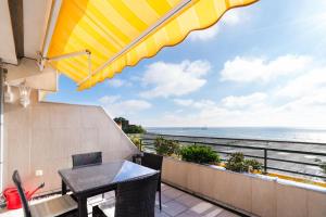 a patio with a table and a view of the ocean at Miramar Whg 513 in Grömitz
