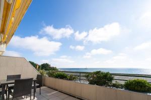 a balcony with a table and chairs and the ocean at Miramar Whg 513 in Grömitz +15 photos