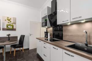 a kitchen with white cabinets and a table and a sink at Solymar Whg 11 in Grömitz