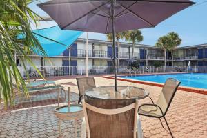 a table and chairs with an umbrella next to a pool at Stayable Davenport in Davenport