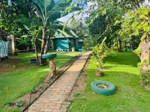 a garden with a brick path and a tree and a house at Oldadai Falls Retreat in Arusha