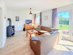 a living room with a couch and a wood stove at Ferienhaus Kranichnest in Breege