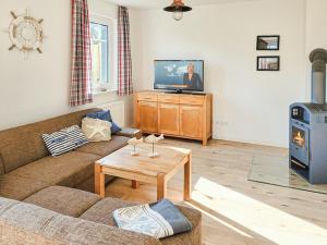 a living room with a couch and a television at Ferienhaus Kranichnest in Breege