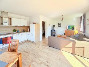 a living room with a couch and a kitchen at Ferienhaus Kranichnest in Breege