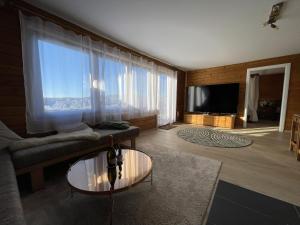 a living room with a couch and a large window at Waldmarie in Grafenau