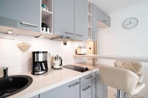 a kitchen with a sink and a coffee maker on a counter at Solymar Whg 29 in Grömitz