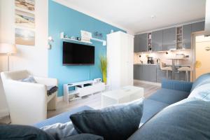 a living room with a couch and a tv at Solymar Whg 29 in Grömitz