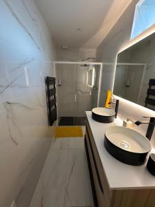 a bathroom with two sinks and a mirror at Maison de Vacances Mon Cocon Bordelais in Villenave-dʼOrnon +7 photos