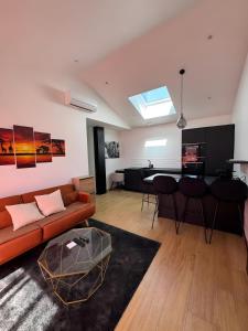 a living room with a couch and a table at Maison de Vacances Mon Cocon Bordelais in Villenave-dʼOrnon