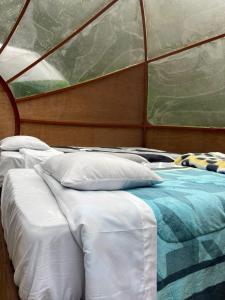 a couple of beds in a room with a window at Chaullay Star Domes in Colcapampa +8 photos
