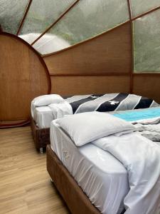 a group of three beds in a room at Chaullay Star Domes in Colcapampa