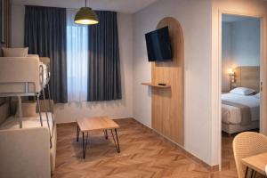 a hotel room with a bed and a tv and a room at Apparthotel Torcy in Torcy