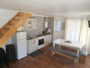a kitchen with white cabinets and a table and a table sidx sidx sidx at Cabañas Felipe in Pichilemu