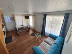 a living room with a blue couch and a table at Cabañas Felipe in Pichilemu