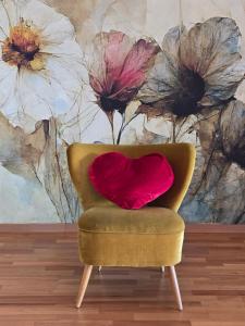a chair with a red pillow in front of a painting at Exklusive Ferienwohnung Bad Salzschlirf - direkt am Waldrand - großer Garten kompett umzäunt - Hunde willkommen - 2 private Stellplätze in Bad Salzschlirf +91 photos