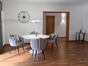 a dining room with a white table and chairs at Exklusive Ferienwohnung Bad Salzschlirf - direkt am Waldrand - großer Garten kompett umzäunt - Hunde willkommen - 2 private Stellplätze in Bad Salzschlirf