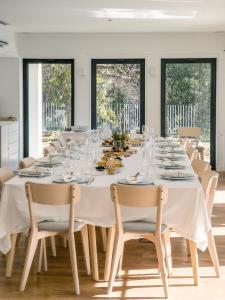 a long dining room with a white table and chairs at Raposa Verde - Agroturismo in Pegarinhos