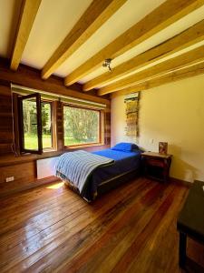 a bedroom with a bed in a room with wooden floors at Casa Arrayan in Puerto Varas