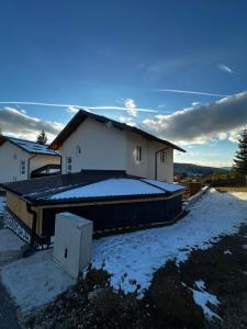 a house with snow on the roof of it at Apartment Vlasic in Šišava