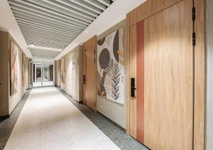 an empty hallway with wooden doors and paintings on the walls at Modern Spaces U-Tower in Tashkent +27 photos