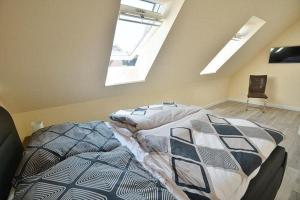 a bedroom with a bed and two skylights at Haus Fischerstraße 6a in Grömitz +6 photos