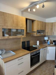 a kitchen with wooden cabinets and a stove top oven at BeachPark Sierksdorf in Scharbeutz