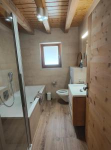 a bathroom with a tub and a toilet and a sink at Chalet l'O - Charm and Modernity in Ovronnaz +27 photos