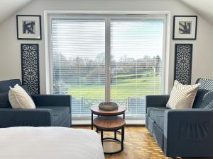 a bedroom with two blue couches and a large window at The Wold - Air-Conditionned Studio Burton Latimer in Burton Latimer +8 photos