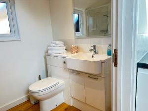 a white bathroom with a toilet and a sink at The Wold - Air-Conditionned Studio Burton Latimer in Burton Latimer