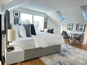 a bedroom with a large white bed and a dining room at The Wold - Air-Conditionned Studio Burton Latimer in Burton Latimer