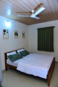 a bedroom with a bed with a ceiling fan at Nirantara Luxury Service Apartment in Gonikoppal