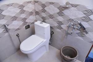 a bathroom with a toilet and a bucket at Nirantara Luxury Service Apartment in Gonikoppal +54 photos