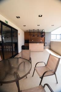 a room with a table and chairs and a kitchen at Flat exclusivo Studio Cuiabá 908 in Cuiabá