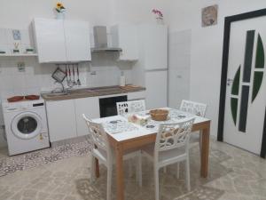 a kitchen with a table and chairs and a washing machine at NEW ROSE HOUSE in Molfetta +8 photos