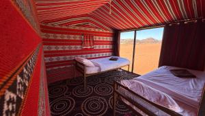 a room with two beds and a window in the desert at Wadi Rum Trip Bedouin Camp in Wadi Rum