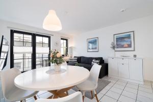 a living room with a white table and chairs at Titania Whg 10 in Grömitz
