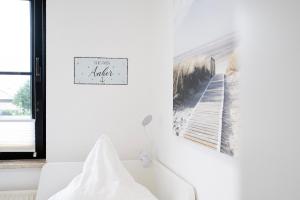 a white room with a white couch and a picture on the wall at Titania Whg 10 in Grömitz