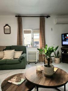 a living room with a green couch and a table at Casa de la abuelita in Cazorla