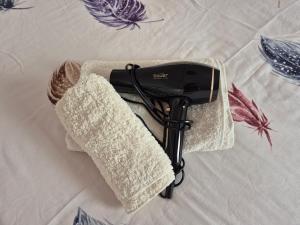 a hair dryer sitting on top of a bed at Luna chalet Zlatibor in Zlatibor