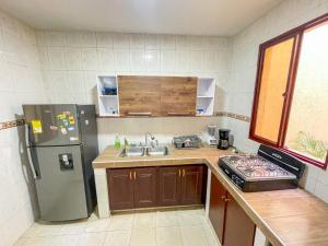 a small kitchen with a refrigerator and a sink at Piazza Granada in Cali