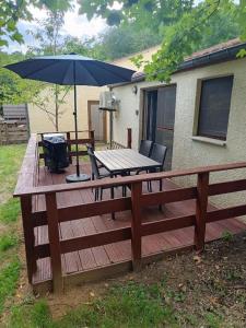 a wooden deck with a table and an umbrella at Casa Gaumaise & Casa Cool in Virton