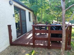 a wooden deck with a picnic table on it at Casa Gaumaise & Casa Cool in Virton