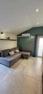 a couch in a living room with a green wall at Casa Gaumaise & Casa Cool in Virton +42 photos