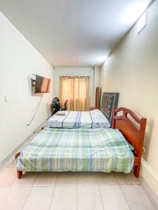 a bedroom with a bed and a tv on a wall at Piazza Granada in Cali