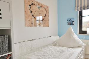 a living room with a white couch and a painting at Titania Whg 7 in Grömitz +4 photos