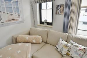 a living room with a white couch with pillows at Titania Whg 7 in Grömitz