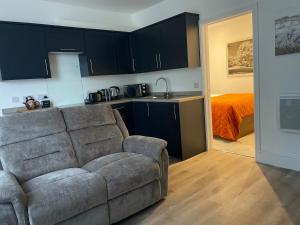 a living room with a couch and a kitchen at Weymouths Coastal Nook in Weymouth