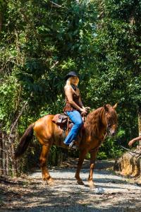 a woman riding on a horse on a path at Villa Gregorio mountain top in Bonao