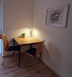 a table with two chairs and a lamp on it at Ferienwohnung Sunny 2 in Mittenwalde
