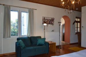 a living room with a blue couch and windows at Holiday Cottage in Lílaia +10 photos